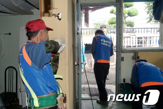 코레일 강원본부 전기처 직원을 비롯한 해오름 봉사회 회원들이 29일 동해시 송정동의 지체장애인 집을 방문해 집수리 봉사활동을 펼치고 있다. (사진제공=코레일 강원본부) 2014.7.29/뉴스1