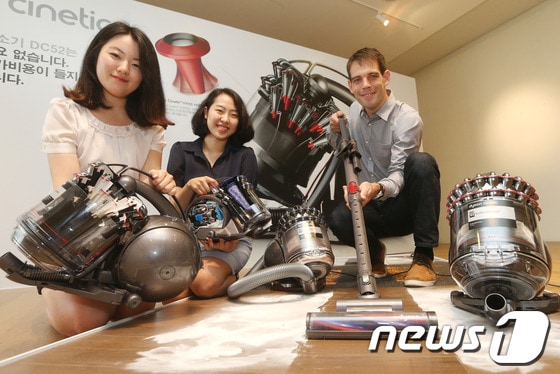 영국 기술기업 다이슨(Dyson) 수석디자이너와 여성들이 3일 오전 서울 종로구 견지동 한 전시장에서 신제품 유선 진공청소기 DC52, DC63 출시를 기념해 제품을 선보이고 있다. 2014.7.3 머니투데이/뉴스1 ⓒ News1