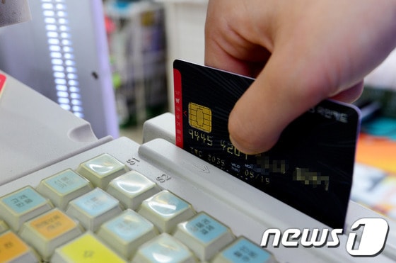 7월 6일 오후 경기도 성남시의 한 가게에서 한 시민이 카드를 이용하고 있다. 2014.7.6/뉴스1 © News1 손형주 기자