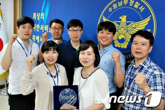 인터넷 물품사기 피해자 49명으로부터 전달받은 감사패를 들고 파이팅을 외치고 있는 수원남부경찰서 사이버수사팀 직원들. © News1