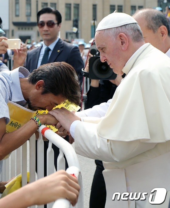 프란치스코 교황이 2014년 8월 16일 서울 광화문 광장에서 열린 '윤지충 바오로와 동료 순교자 123위 시복식' 카 퍼레이드 도중 오픈카에서 내려 '세월호 특별법' 제정을 요구하며 단식중인 '유민 아빠' 김영오(47)씨를 위로하고 있다. (교황방한위원회 제공) 2014.8.16/뉴스1