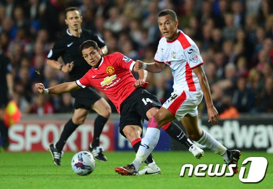 맨체스터 유나이티드의 하비에르 에르난데스(왼쪽)가 27일(한국시간) 잉글랜드 밀턴 케인스 MK스타디움에서 열린 2014-2015 캐피털원컵 2라운드에서 MK돈스의 델레 알리를 제치고 공을 패스하고 있다. ⓒ AFP=News1