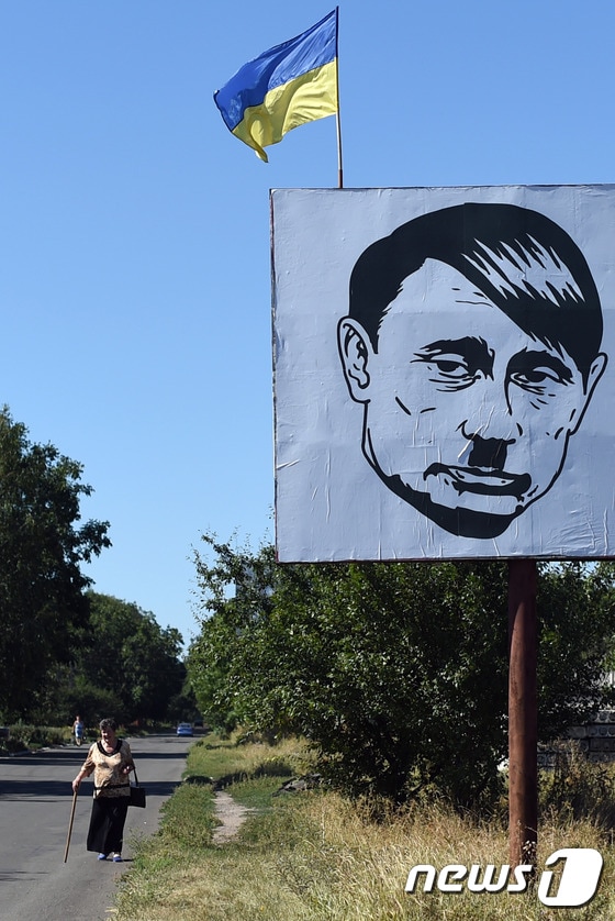 우크라이나 도네츠크 인근의 한 마을에 히틀러와 비슷하게 묘사한 푸틴 대통령의 그림이 걸려 있다.ⓒ AFP=뉴스1