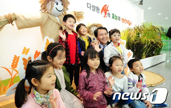 12일 오전 전북 전주시 완산구 농촌진흥청 농업과학관에서 열린 '쌀의 다양한 효능과 건강 지킴이 특별전시회'에서 이양호 농진청장이 견학온 어린이들과 함께 기념사진을 찍고 있다. 이번 전시회는 최고품질벼, 기능성벼, 난장이벼 등 20품종과 흑미, 백미, 적미, 녹미 등 다양한 종자 15종, 컵밥·막걸리·쌀국수·쌀빵 등 쌀로 만든 가공식품 25종, 전국 유명 브랜드 쌀 12종을 전시된다. 2015.10.12/뉴스1 ⓒ News1 김대웅 기자