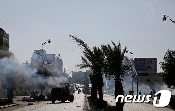 이스라엘군이 라말라 북부 지역의 유대인 정착촌 베이트 알 지역에서 시위를 벌이는 팔레스타인 시위대를 향해 최루가스를 발포하고 있다. ⓒ AFP=뉴스1