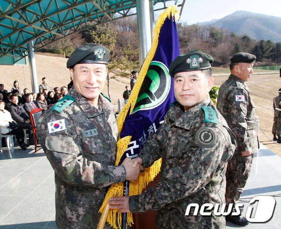 제7대 육군화학과훈련단 한경록 단장이 나상웅 교육사령관에게 부대기를 이양받고 있다.제6대·제7대 육군 과학화전투훈련단(KCTC) 이·취임식이 17일 과학화훈련단 연병장에서 열렸다. (사진제공=육군과학화훈련단)2015.12.17/뉴스1 ⓒ News1 정진욱 기자