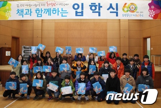 2일 강원 춘천시 소양중학교 신입생들이 책 1권과 독서수첩 등이 담긴 책 꾸러미를 선물하는 "책 읽는 입학식"을 치른 뒤 기념사진을 찍고 있다. 2015.3.2/뉴스1 2015.03.02/뉴스1 ⓒ News1 이예지 기자