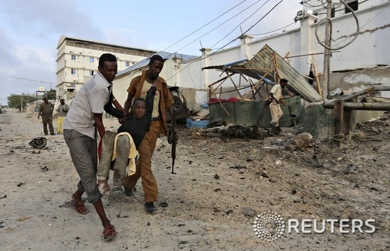 소말리아 모가디슈 주민들이 27일(현지시간) 이슬람 급진주의 무장세력 알샤바브의 호텔 테러로 다친 사람을 이송하고 있다.ⓒ 로이터=뉴스1