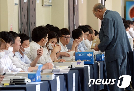 12일 오전 서울 서초구 서울중앙지방법원 3별관 제1호 법정에서 열린 팬오션 변경회생계획안 결의 관계인집회에서 소액주주들이 회생채권 순번 확인을 하고 있다. 2015.6.12/뉴스1 ⓒ News1 신웅수 기자