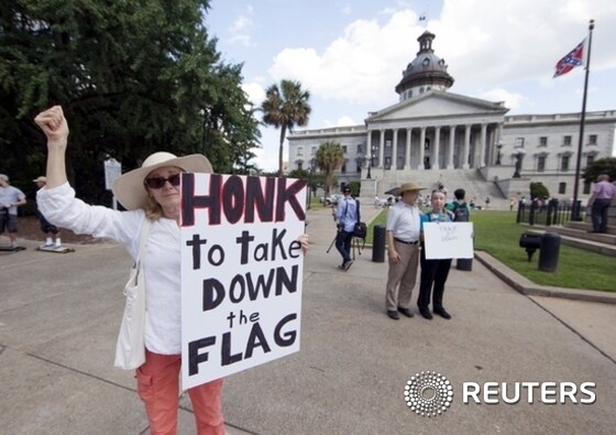 Sheila DiCiorrio holds a sign asking for the confederate battle flag that flies at the South Carolina State House to be removed in Columbia