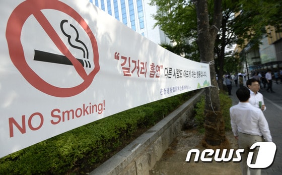 15일 서울시내 거리에 길거리 흡연 금지 안내문이 붙어있다. 보건복지부는 지난해 9월 담뱃값 2000원 인상안이 포함된 금연종합대책 발표 이후 1년여 기간 동안 성인남성 흡연율이 5.8% 하락했다고 밝혔다. 복지부는 오는 2020년까지 흡연자의 대부분을 차지하는 성인남성 흡연율을 29% 이하로 떨어트리는 정책을 추진 중이다. 2015.7.15/뉴스1 ⓒ News1