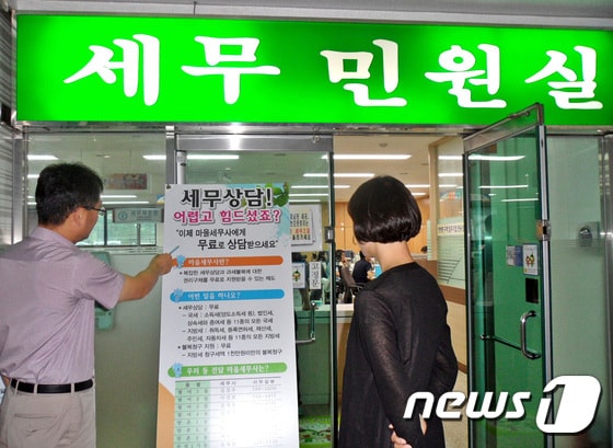 대구 수성구 주민들이 지난 21일 수성구청 민원실 앞에 세워진  마을세무사 제도 홍보 배너를 바라보고 있다./사진제공=대구 수성구청 ⓒ News1