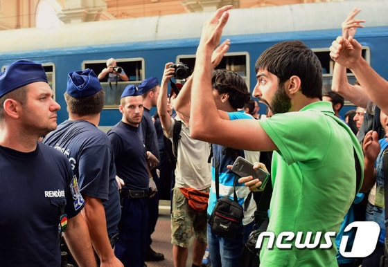 헝가리가 더블린조약 위반 논란에 휩싸이자 부다페스트 역사 열차운행을 중단하고 폐쇄했다 이에 역사에서 쫓겨난 난민들이 경찰을 향해 항의하고 있다. ⓒ AFP=뉴스1
