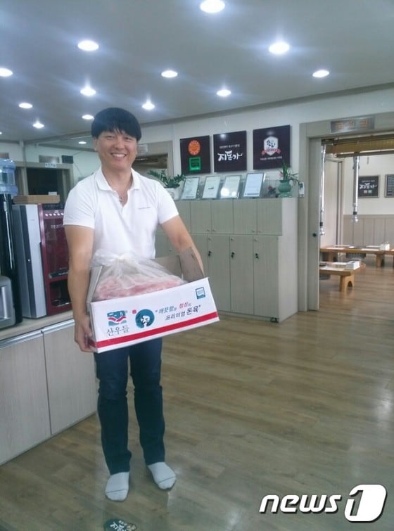 24일 예산읍 주교리 지돈가에서 사회복지시설 관계자가 돼지고기를 전달받고 있다.ⓒ News1