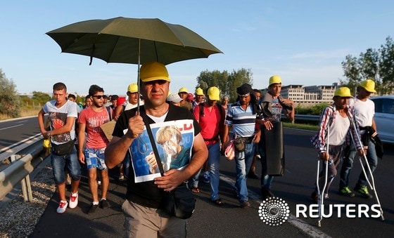 4일(현지시간) 헝가리 부다페스트의 켈레티 기차역에서 머물던 난민 1200여명이 오랜 열차 출발 중단 조치에 참지 못하고 걸어서 독일로 이동하기 시작했다. 다리가 불편해 목발을 짚고 있는 난민도 행진에 참여한 가운데 한 남성이 앙겔라 메르켈 독일 총리의 사진을 손에 든 채 걷고 있다. 이들의 1차 목표지는 오스트리아 수도 빈으로 부다페스트에서 빈까지의 거리는 240㎞가 넘어 걸어서는 약 50시간이 걸린다.ⓒ 로이터=뉴스1 / (부다페스트 로이터=뉴스1)