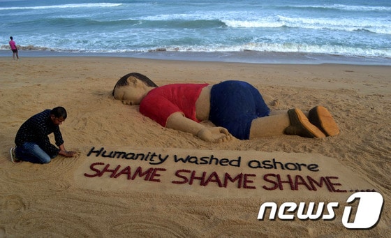 인도 예술가인 수라드산 파트나익이 4일(현지시간) 인도 부바네스와르 인근 푸리 해안에 세 살배기 난민 아일란 쿠르디를 기리는 모래 조형물을 만들었다.  ⓒ AFP=뉴스1