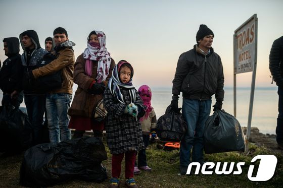 터키와 아프가니스칸의 이주자들과 난민들이 27일(현지시간) 터키 차나칼레에 있는 쿠추쿠유 지구에서 터키 경찰에 잡힌 뒤 대기하고 있다. ⓒ AFP=뉴스1