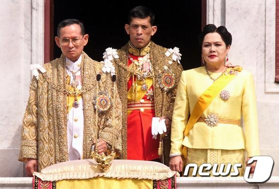 13일(현지시간) 서거한 푸미폰 아둔야뎃 태국 국왕(왼쪽)과 시리킷 키티야카라 왕비(오른쪽), 아들인 마하 와찌랄롱꼰(64) 왕세자가 함께 서 있다. 사진은 1999년 12월 촬영됐다. ⓒ AFP=뉴스1