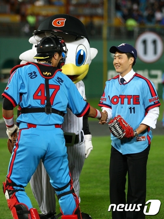 고 최동원선수 장남 최기호씨가 시구를 하고 롯데 강민호 선수와 악수를 하고 있 다.(롯데야구단 사진제공)ⓒ News1 강영범기자