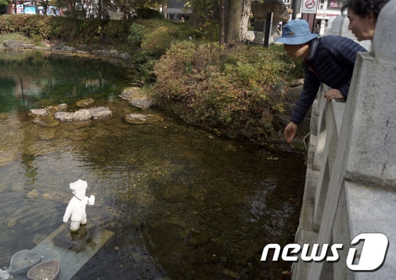 18일 태백시티투어 참가자들이 낙동강 발원지 강원 태백 황지연못을 방문해 소망을 담아 동전을 던지고 있다. 2016.10.18/뉴스1 ⓒ News1 하중천 기자