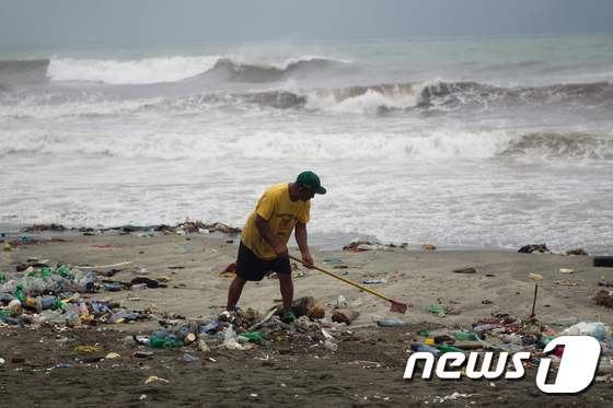 허리케인 '매튜'의 영향으로 쓰레기가 밀려온 도미니카 공화국 산토도밍고의 해안가에서 주민들이 청소를 하고 있다. ⓒ AFP=뉴스1