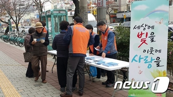 박행규 한전 진해지사장(오른쪽)이 21일 진해 중앙시장 부근에서 지나가는 시민들을 대상으로 전기요금 복지할인 제도를 안내하는 홍보물을 배포하고 있다.(한국전력공사 진해지사 제공)ⓒ News1