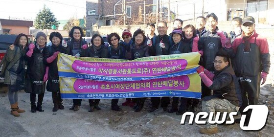 지난 24일 속초시 중앙동 일대에서 미시령동서관통도로(주)와 속초시여성단체협의회 관계자들이 1500장의 연탄을 배달하고 기념으로 사진촬영하는 모습(미시령동서관통로 제공).2016.11.25 ⓒ News1 고재교 기자