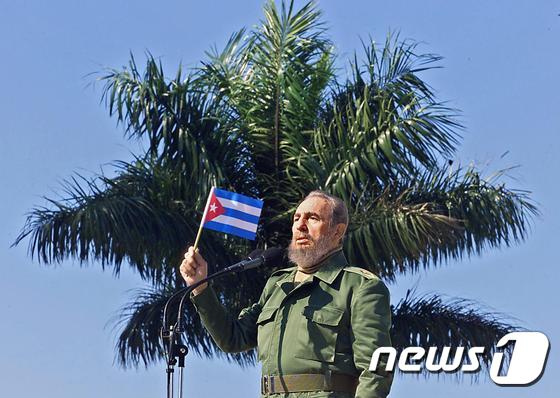 2001년 1월 27일 쿠바 수도 아바나 인근 도시 산호세데라스라하스를 방문한 피델 카스트로 당시 국가평의회 의장이 국기를 들고 있다. 쿠바 공산혁명 지도자 카스트로 전 의장은 26일 타계했다. ⓒ AFP=뉴스1 ⓒ News1 최종일 기자