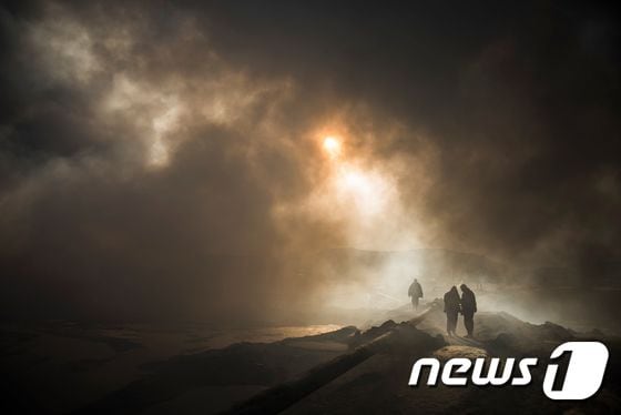 이슬람국가(IS)가 이라크 모술 인근에 저지른 대규모 유전 화재가 지속되면서 지난달 20일(현지시간) 알콰야라 마을에 독성 가스가 피어오르고 있다. ⓒ AFP=뉴스1