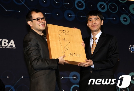 이세돌 9단이 15일 오후 인공지능 알파고와의 ‘구글 딥마인드 챌린지 매치’ 5번기 제5국을 마친 뒤 서울 광화문 포시즌스호텔에서 데미스 하사비스 구글 딥마인드 대표에게 바둑판에 사인을 해서 선물을 하고 있다. ⓒ News1 송원영 기자