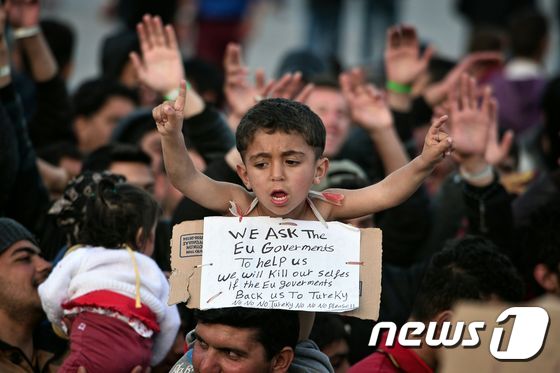 그리스 키오스 섬의 항구에서 한 난민 어린이가 “터키는 싫어요” 라는 구호를 외치고 있다. 난민들은 유럽연합(EU)과 터키의 합의에 따라 키오스 섬을 포함한 5개의 에게섬 난민센터에 분산 수용돼 있다.ⓒ AFP=뉴스1 ⓒ News1