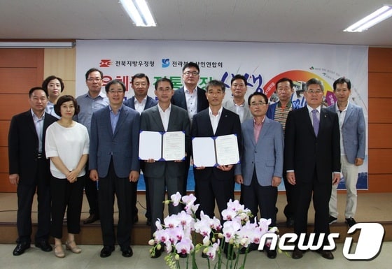 전북지방우정청과 전라북도상인연합회가 12일 전통시장 활성화를 위한 업무협약을 체결했다.(사진제공=전북우정청)ⓒ News1