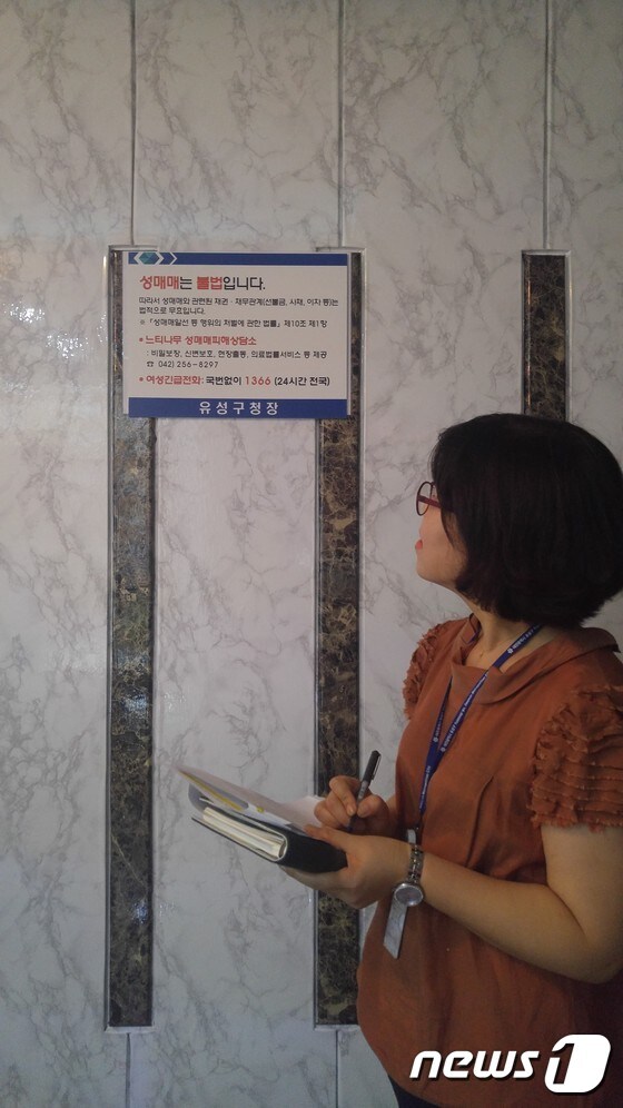 유흥주점에 붙어있는 게시물을 확인하고 있는 모습.ⓒ News1