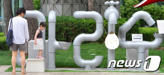 서울 중구 서울시청 앞에 설치된 아리수 음수대 앞에서 어린이가 노닐고 있다.  2016.7.3/뉴스1 ⓒ News1 구윤성 기자