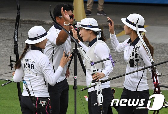 여자 양궁 대표팀 기보배, 최미선, 장혜진이 7일(현지시간) 브라질 리우데자네이루 삼바도로 경기장에서 열린 리우하계올림픽 양궁 여자 단체전에서 10점을 쏜 뒤 양창훈 감독과 하이파이브를 하고 있다.2016.8.8/뉴스1 ⓒ News1 이광호 기자