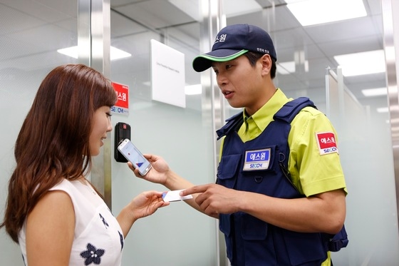 에스원 출동요원이 고객에게 모바일 보안카드 사용법을 설명하고 있다. ⓒ News1