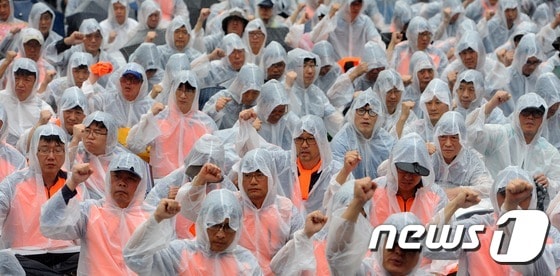 철도 노조 파업 2일차인 28일 오후 부산 동구 부산역 광장에서 열린 '민주노총 총파업 총력투쟁 결의대회'에 참석한 노조원들이 비를 맞으며 구호를 외치고 있다. 2016.9.28/뉴스1 ⓒ News1 여주연 기자