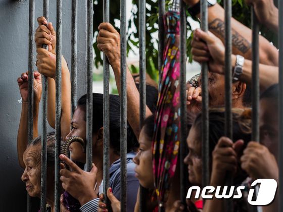 8일(현지시간) 브라질 아마조나스 주 마나우스의 한 교도소에서 폭동이 일어나 최소 4명이 사망했다. 사진은 폭동이 진압된 후 소식을 기다리는 재소자들의 가족들. ⓒ AFP=뉴스1