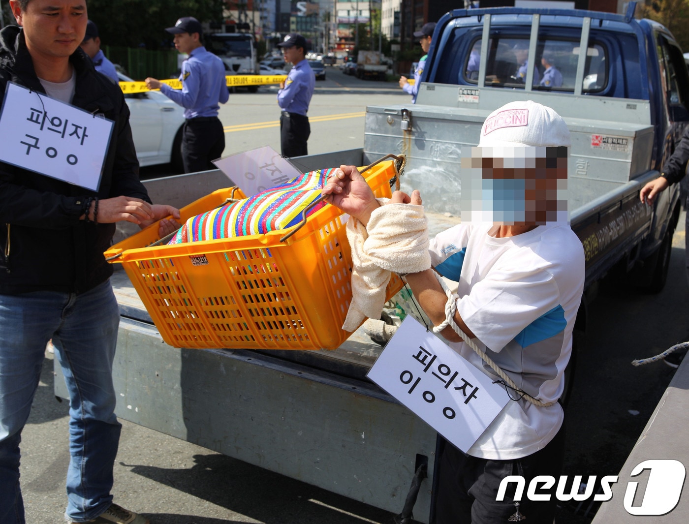 부산항 제2부두에서 이불에 싸인 채 시신이 떠오른 사건과 관련해 3일 오전 부산 남구 문현동 범일교에서 살해 피의자 공범 이모씨(45)가 범행 당시 피해자 김모씨(56·여)의 시신을 노란 바구니에 담아 다리 밑으로 던지는 장면을 재연하고 있다.(부산해양경찰서 제공) ⓒ News1 조아현 기자