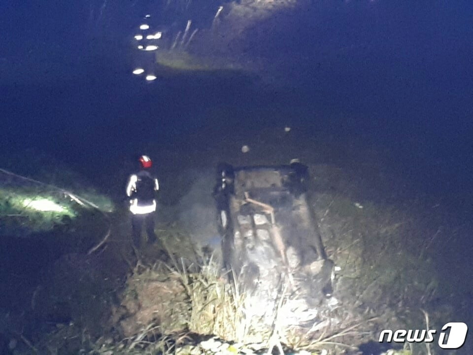 18일 오전 6시쯤 제주시 애월읍 유수암리 평화로에서 박모씨(34여)가 몰던 경차가 도로 옆 3m 아래로 떨어지며 차에 불이나 소방관들이 진화하고 있다(제주소방안전본부 제공)ⓒ News1