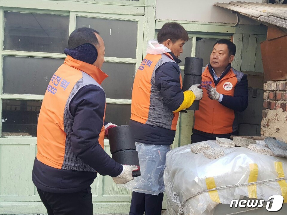 한국전력공사 진해지사 김선안 지사장(맨 오른쪽)이 20일 창원시 진해구에 거주하는 저소득층 가구에 연탄을 배달하고 있다.(한국전력공사 진해지사 제공) 2017.12.20./뉴스1ⓒ News1