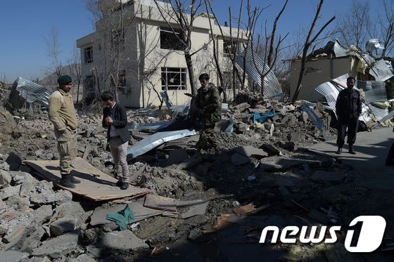 아프간 안보당국이 2일(현지시간) 테러로 폐허가 된 카불 경찰청사 앞을 지나고 있다. ⓒ AFP=뉴스1