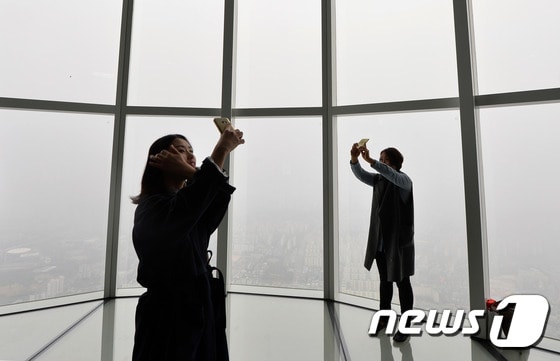 6일 오후 서울 송파구 롯데월드타워 전망대에서 시민들이 안개 낀 서울을 배경으로 '셀카'를 찍고 있다. 기상청은 "전국이 대체로 흐리고 중부서해안과 일부 내륙에 안개가 짙게 낀 곳이 있다＂며 주의를 당부했다.2017.4.6/뉴스1 ⓒ News1 구윤성 기자