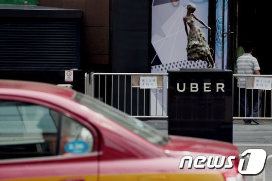 중국 베이징의 한 쇼핑몰 앞에 있는 우버 정거장 앞으로 현지 택시가 지나가고 있다. ⓒ AFP=뉴스1