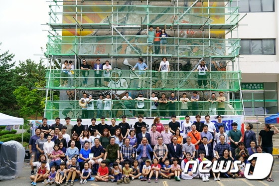 19일 전남대 사범대 1호관 벽에 그려진 '광주민중항쟁도' 복원 작업에 앞서 벽면에 가설제 구조물을 설치하고 참여 작가와 시민들이 기념촬영을 하고 있다.(추진위 제공)2017.8.20/뉴스1 ⓒ News1 박준배 기자