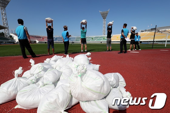 14일 강원도 강릉시 종합운동장에서 진행된 환경미화원 공개 채용 체력시험에 참가한 남자 응시자들이 검정 종목 중 하나인 30㎏ 모래주머니 들고 버티기를 치르고 있다. 2017.9.14/뉴스1 ⓒ News1 서근영 기자