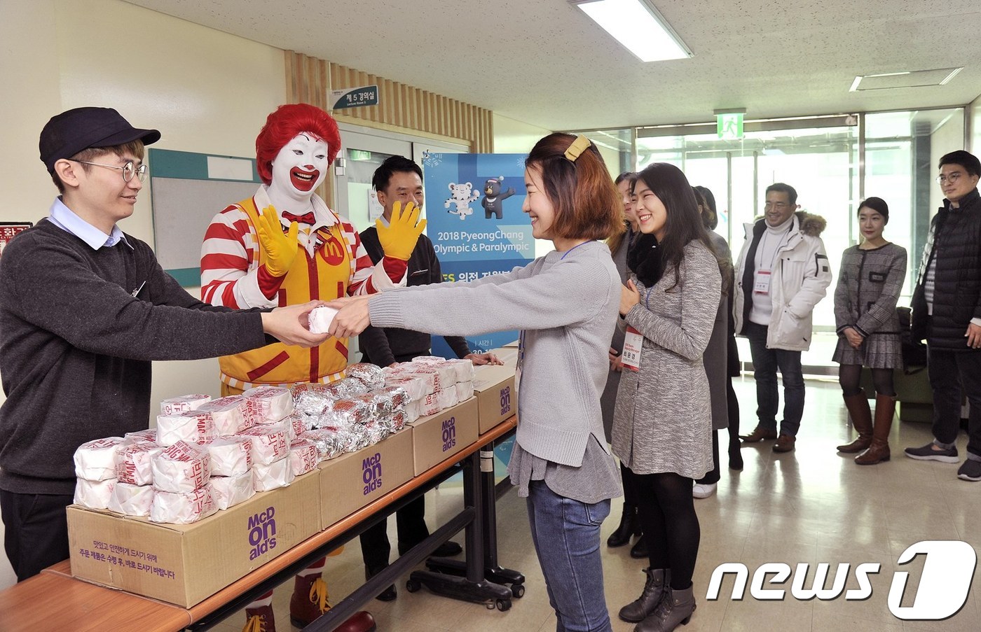 맥도날드 직원들과 마스코트 로날드 맥도날드가 2018 평창 동계올림픽 자원봉사자들에게 햄버거를 전달하고 있다. ⓒ News1