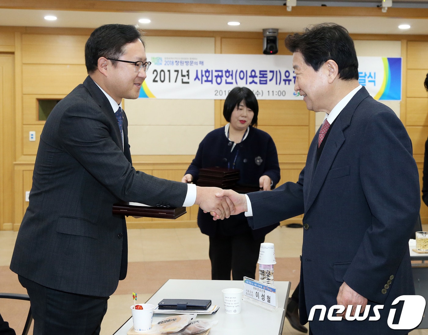 BNK경남은행 사회공헌홍보부 이성철 부장(왼쪽)이 21일 창원시청에서 안상수 시장으로부터 2017 사회공헌(이웃돕기) 유공자 감사패를 수여 받고 악수를 하고 있다.(경남은행 제공)2018.2.21./뉴스1ⓒ News1