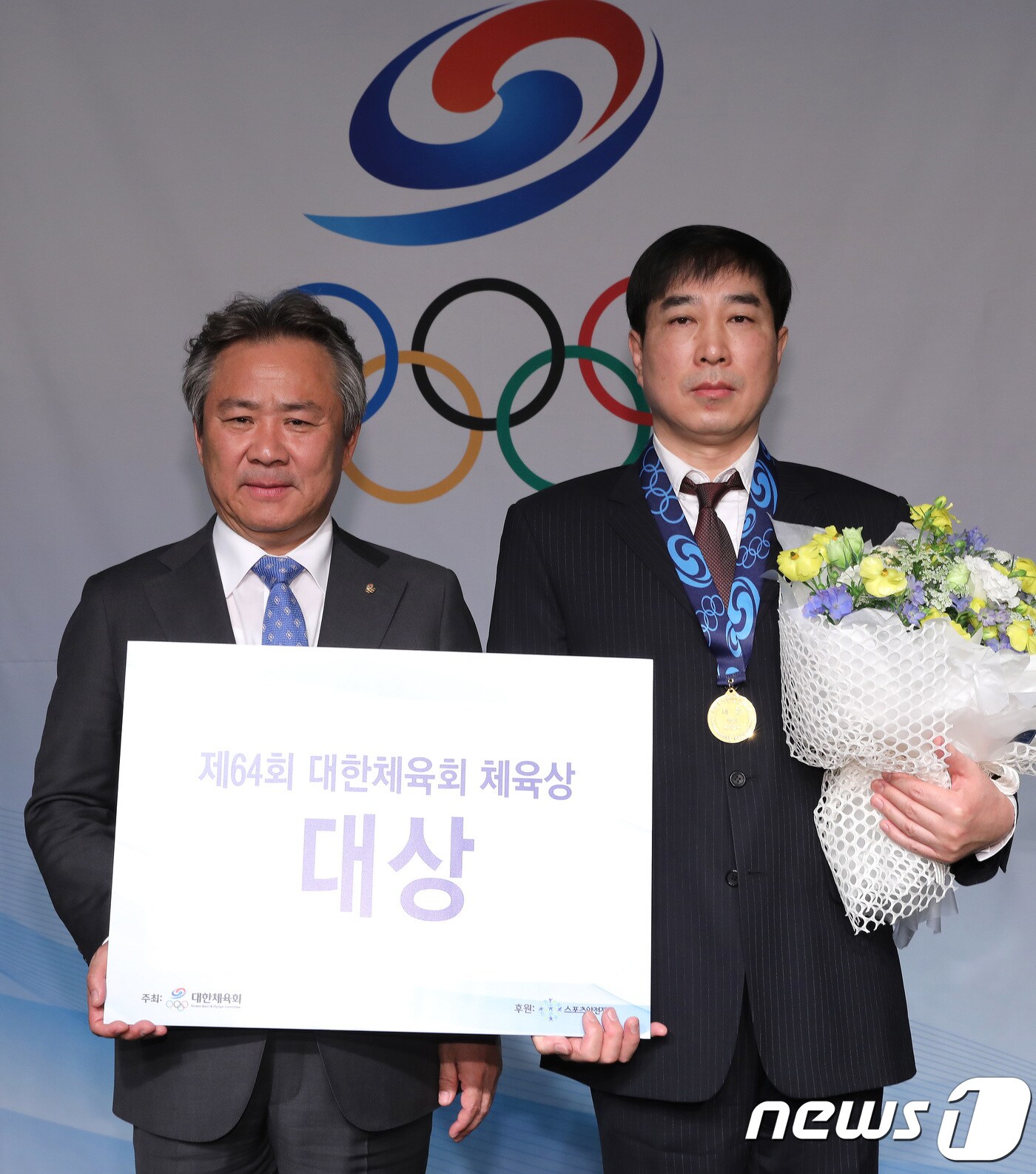 28일 오전 서울 송파구 방이동 올림픽파크텔에서 열린 제64회 대한체육회 체육상 시상식에서 체육대상을 받은 김민석 선수의 아버지 김남수 씨가 대리수상을 하고 있다. 김민석은 2018 평창동계올림픽 스피드스케이팅 남자 팀추월에서 은메달을 1,500m에서 동메달을 차지했다. 왼쪽은 이기흥 대한체육회장. 2018.2.28/뉴스1 ⓒ News1 임세영 기자