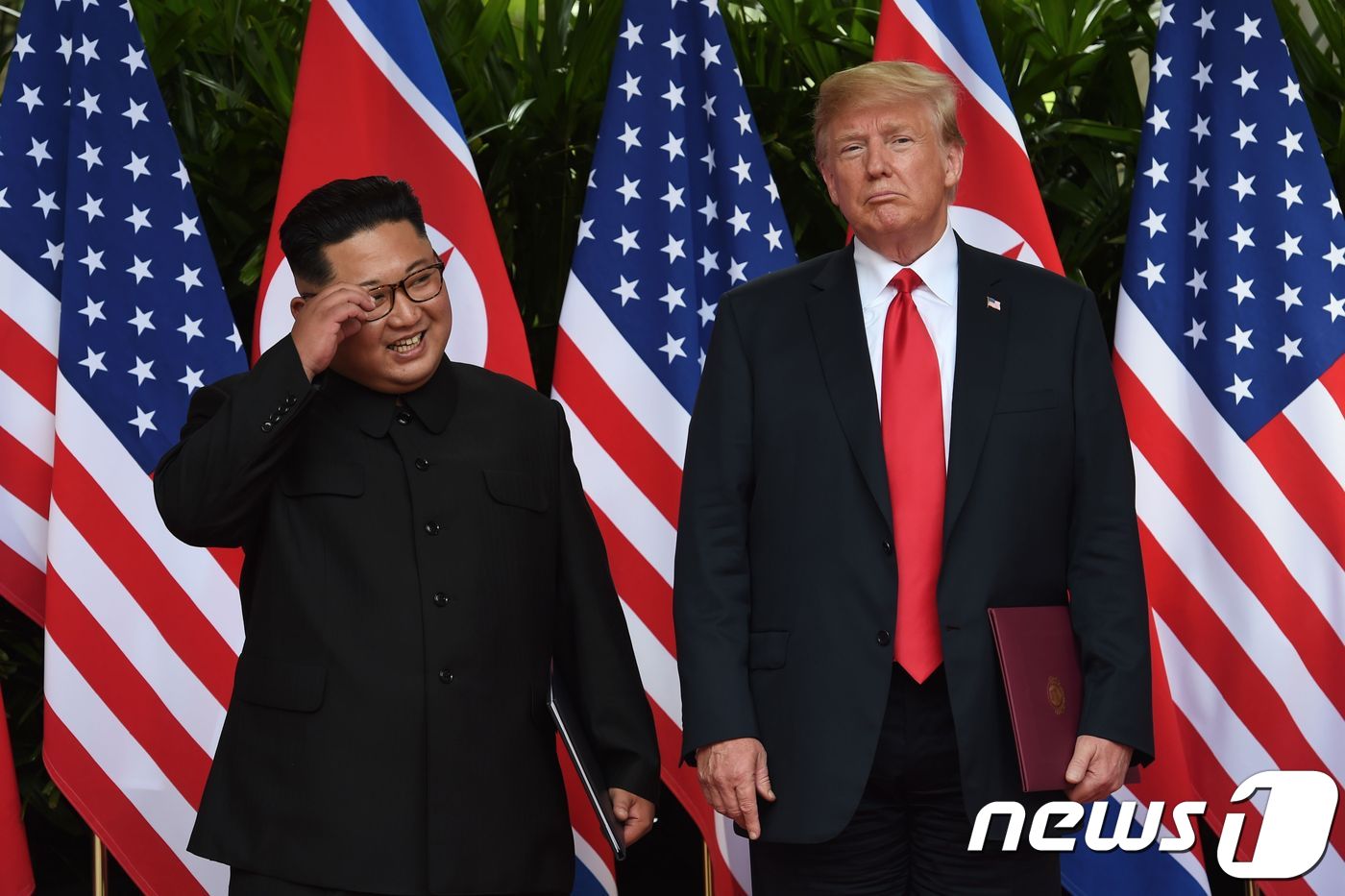 김정은 북한 국무위원장과 도널드 트럼프 미국 대통령이 2018년 6월 12일(현지시간) 싱가포르 센토사 섬 카펠라 호텔에서 북미정상회담을 마친 뒤 공동합의문 서명식에서 나란히 서 있다. ⓒ AFP=뉴스1